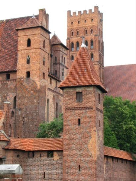 Malbork - widok baszta obronna w oddali wieża zamku wysokiego