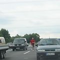 Zdjecie wykoname na niemieckiej autostradzie przez tylna szybe szamochodu.Pan w czerwonej koszulce wyszedł w korku' za potrzeba',niestety w tym momecie korek ruszył .Taraz odbywa sie wyścig z czasem.Dogoni samochod czy nie???